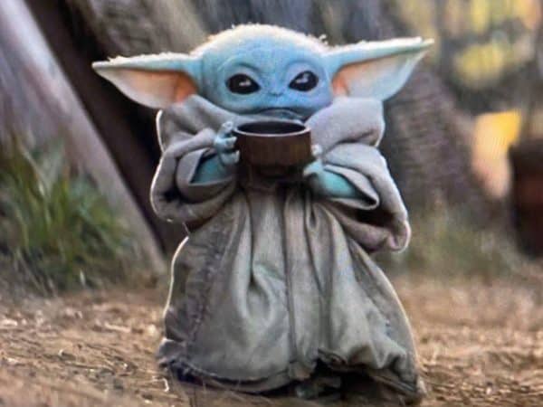 Baby Yoda holding a cup of soup