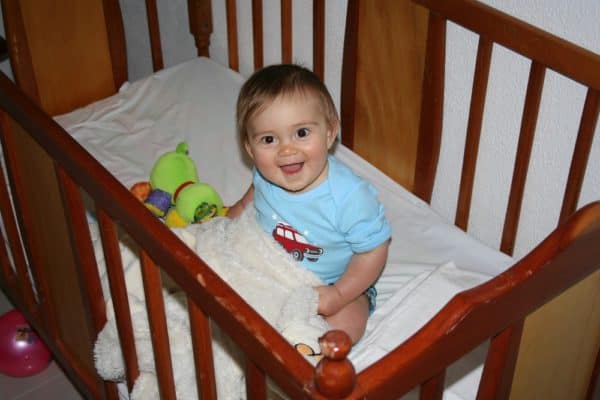 Happy baby in his crib waking up in the morning